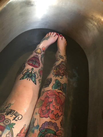 Tattooed legs in the bath tub after full recovery