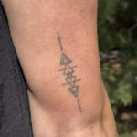 A female physical therapist with a small, discreet tattoo on her wrist, interacting with a patient. The tattoo is barely visible and does not detract from her professional appearance; it demonstrates how a small tattoo can be both personal and professional, fitting into a healthcare setting without causing distraction.