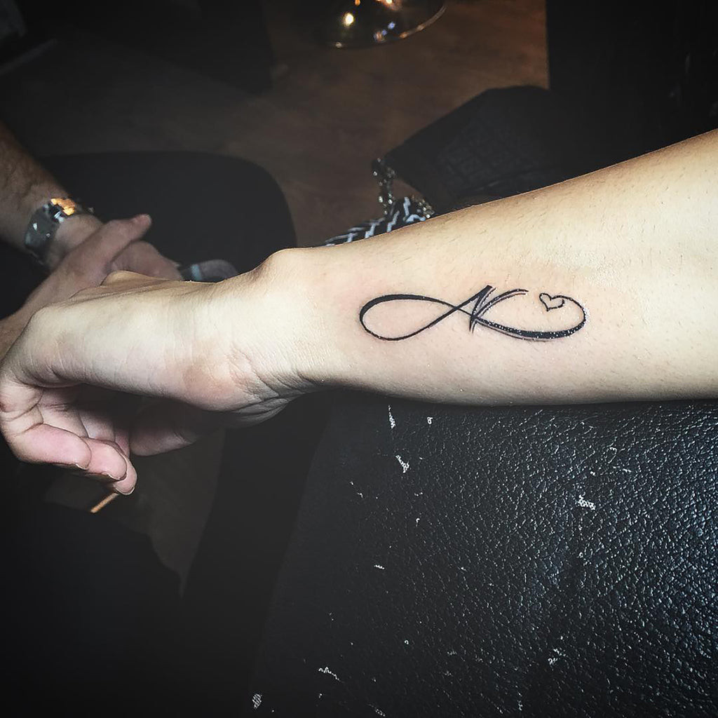 An example of intertwined nature design with initial tattoo