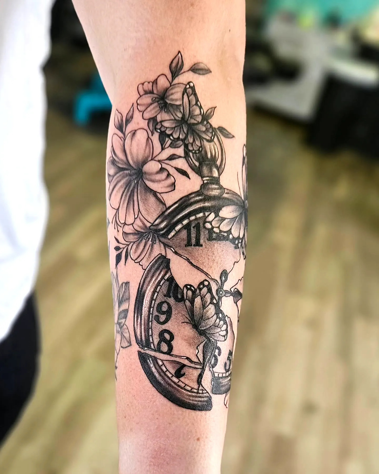 Intricate Broken Clock Tattoo with Blooming Flowers on Forearm