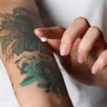 Woman applying CeraVe to tattooed skin