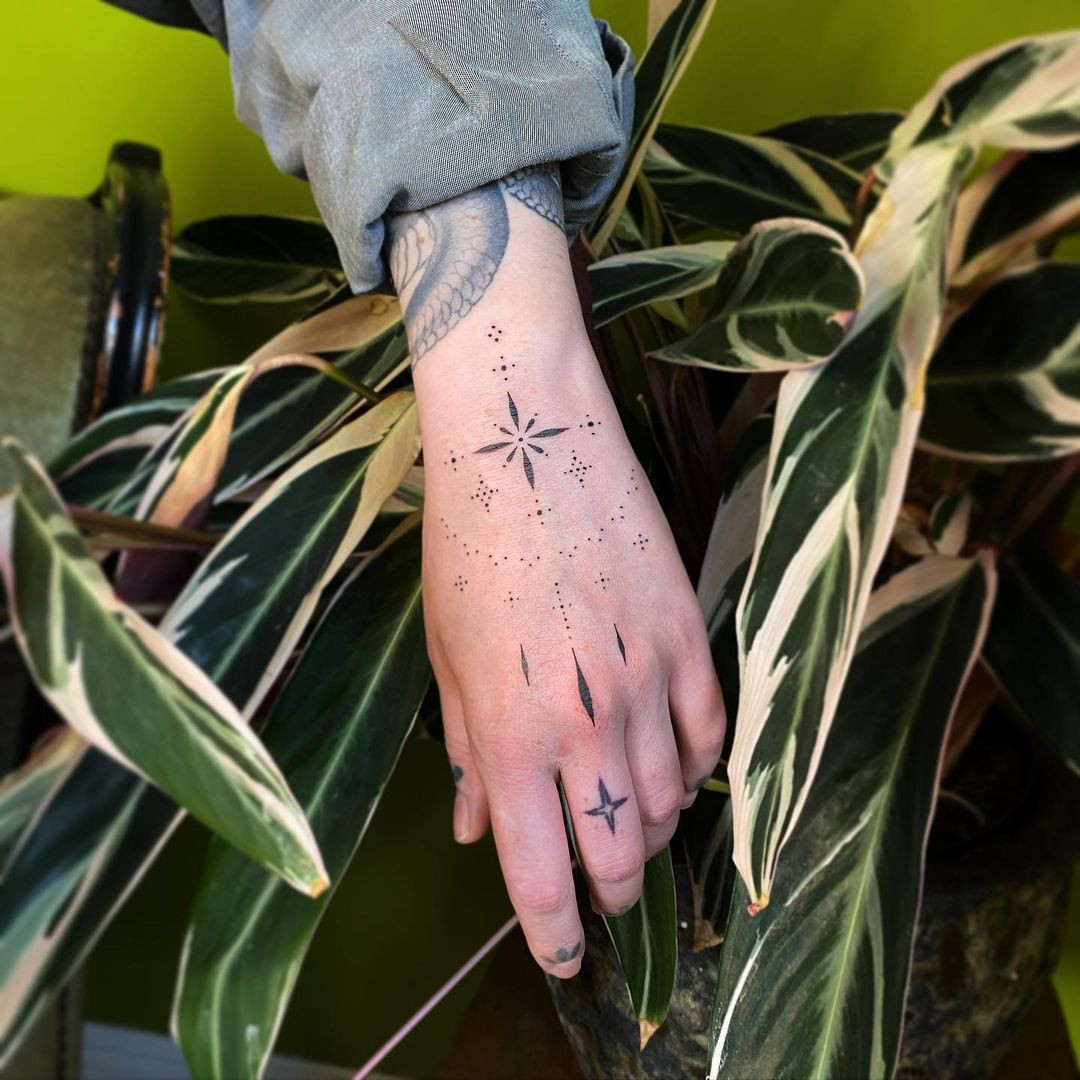 A dotwork ornamental tattoo on a woman's hand, highlighting the intricate dotwork that resembles delicate jewelry.