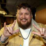 Jelly Roll flashing I love you hand signs and smiling