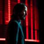Keanu Reeves as John Wick showing the back tattoo