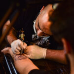 Tattoo artist wearing gloves and using sterile equipment
