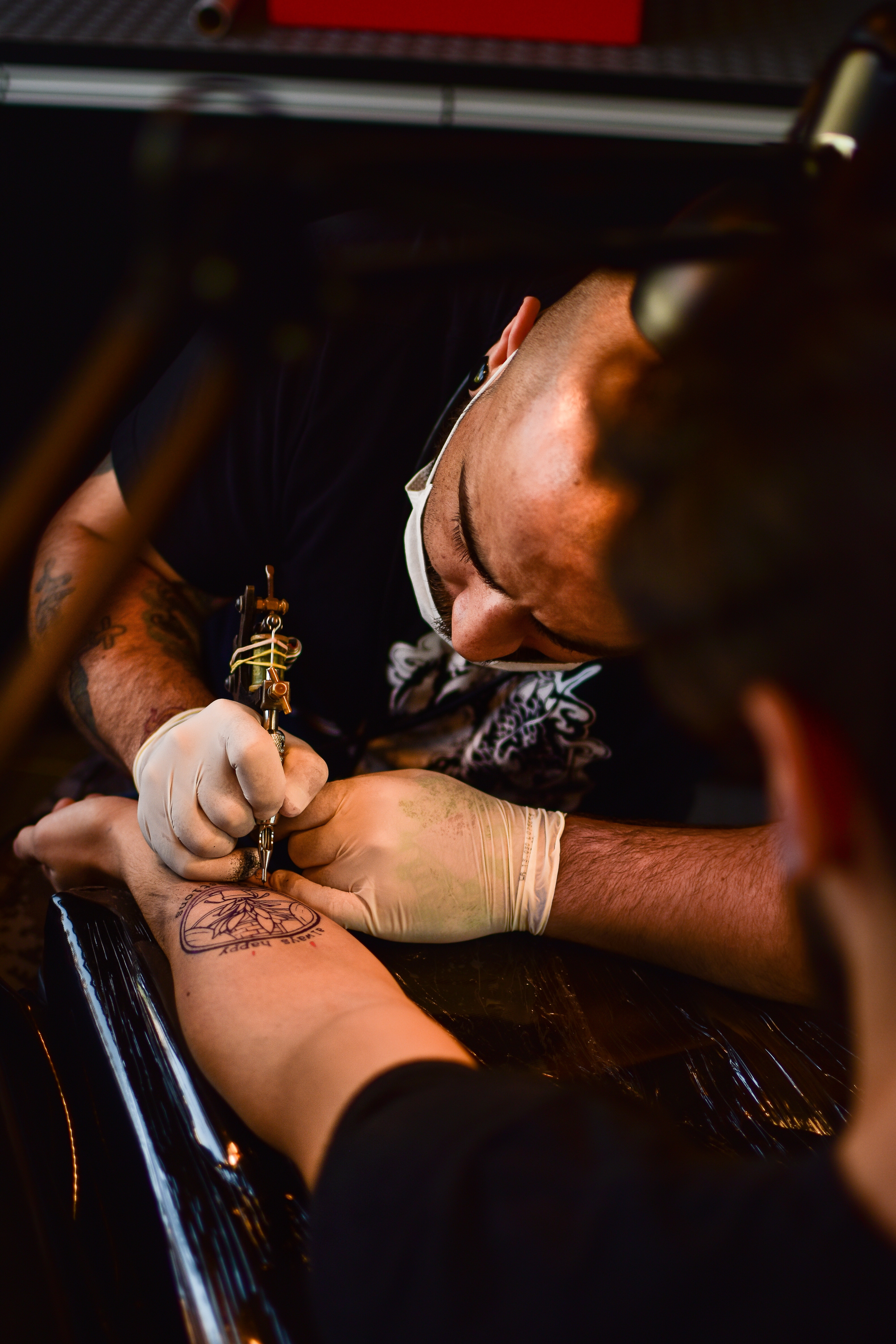 Tattoo artist wearing gloves and using sterile equipment