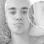 Justin Bieber's tiny face cross tattoo, subtly placed near the eye