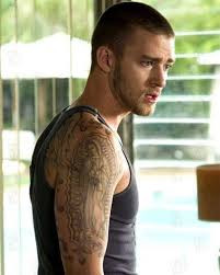 Justin Timberlake with fake tattoos for the movie Alpha Dog, showcasing a tough, gangster-like appearance achieved through temporary body art.