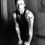 Justin Timberlake's cross tattoo on his left arm, symbolizing his religious beliefs and upbringing in the Bible Belt.