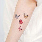 Close-up of a finger tattoo featuring a single, delicate dot.