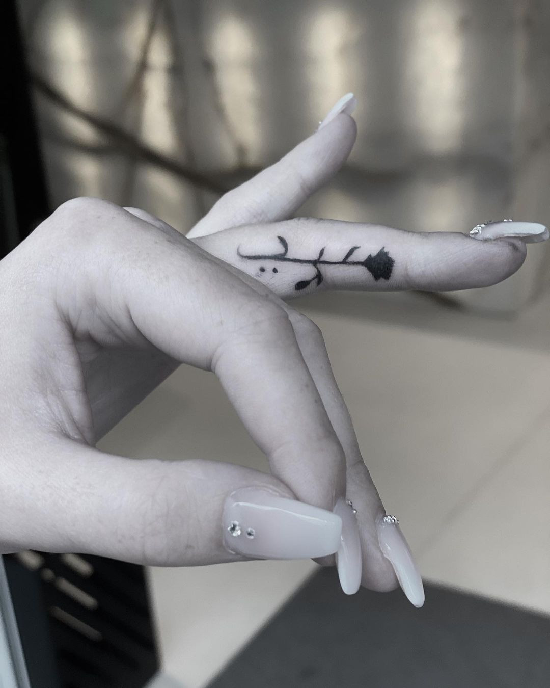 A side finger rose tattoo on a woman's finger, allowing her to flaunt it whenever she chooses, adding a stylish touch.
