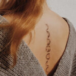 Simple moon phases spine tattoo