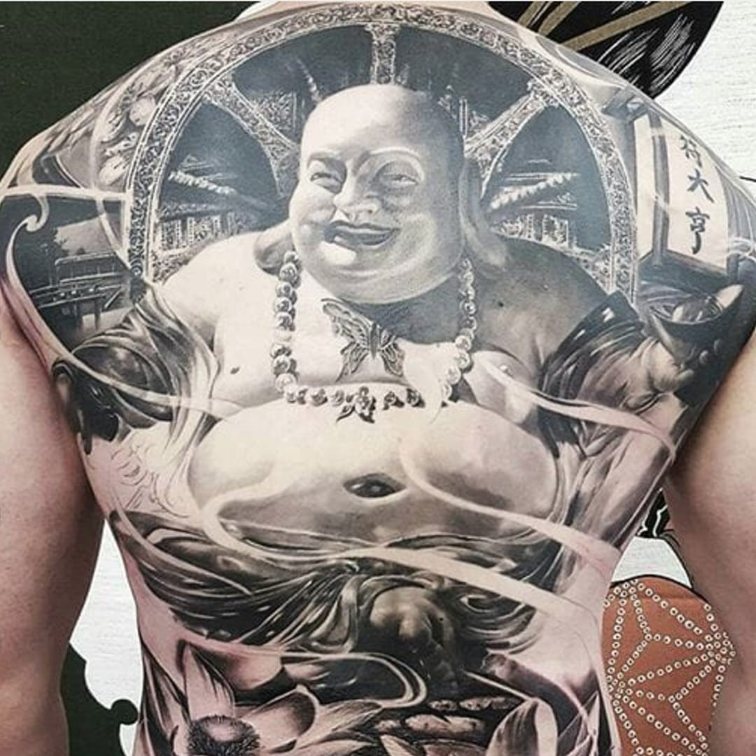 A chilling Buddha tattoo on a back