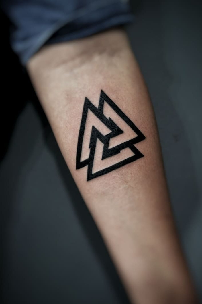 A finger featuring a Valknut tattoo design inspired by Norse mythology.