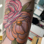 Arm tattoo of colorful flower and butterflies