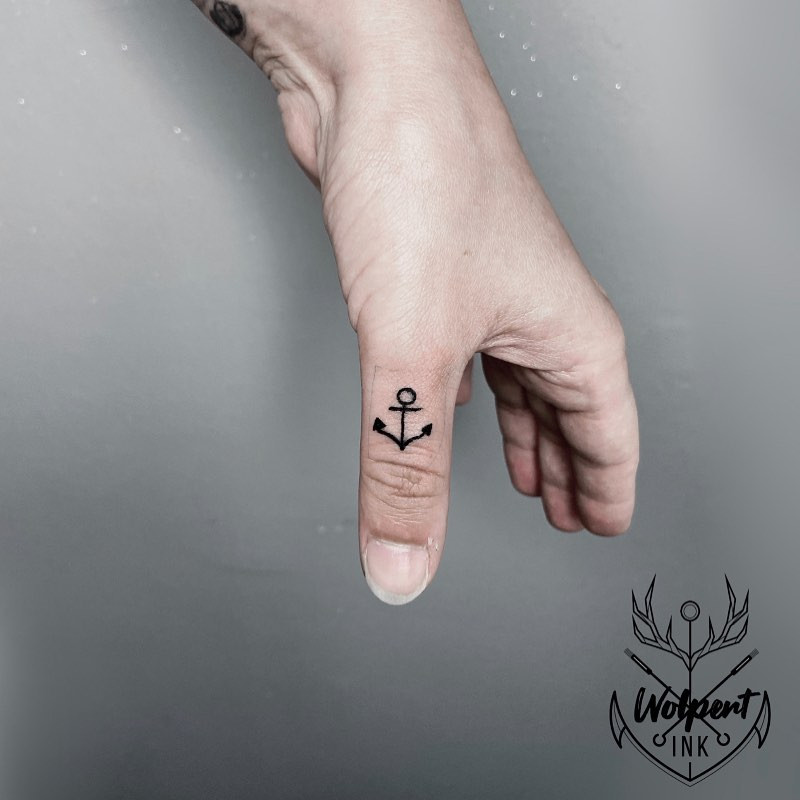 An anchor tattoo on a woman's hand, symbolizing stability, strength, and determination.