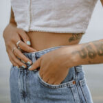 Woman applying lotion to her tattooed arm