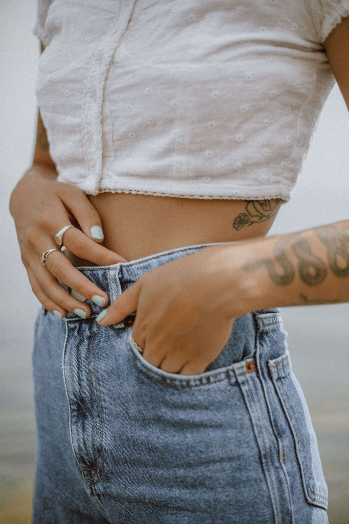 Woman applying lotion to her tattooed arm