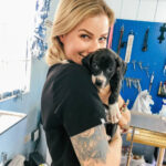 Veterinarian with a subtle arm tattoo examining a dog, showcasing how tattoos can be incorporated in a professional setting while providing care.