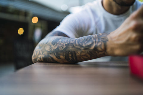 Forearm tattoo pain levels explained, featuring an artistic design