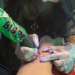 Tattoo artist carefully applying a stencil to a client's arm before starting the tattoo