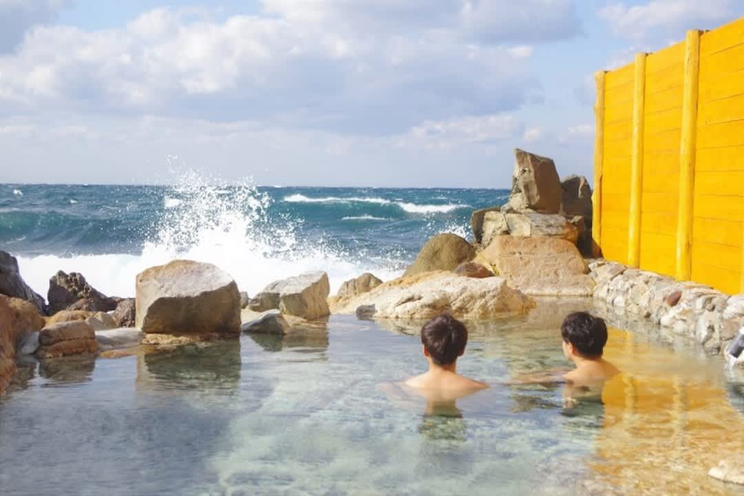 A couple enjoying a private onsen with visible tattoos, illustrating an inclusive bathing experience in Japan
