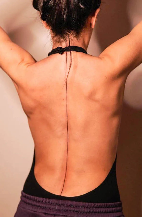 Simple spine tattoo featuring a single line running down the spine, created by @tuzee_tattoo
