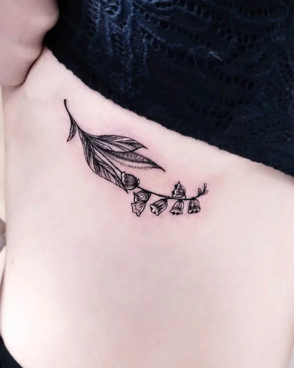 Small flower tattoo under boob with bold lines and striking contrast.