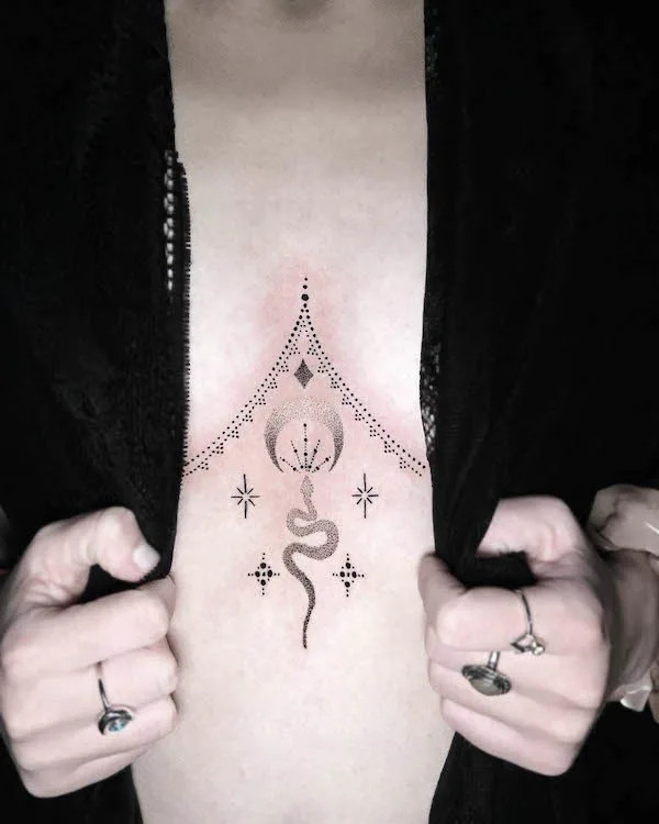 Small snake underboob tattoo adorned with elegant ornaments.