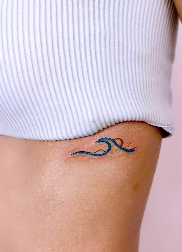 Small wave and sun rib tattoo capturing the harmony of ocean waves.