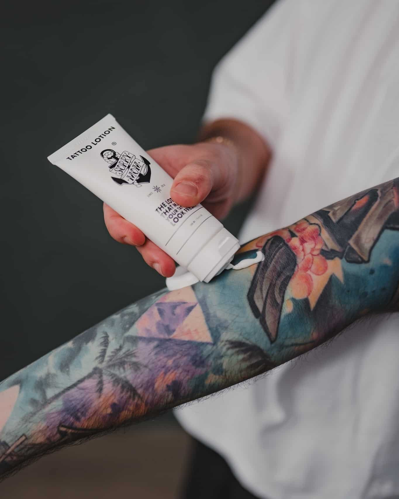 Applying lotion on arm with tattoo
