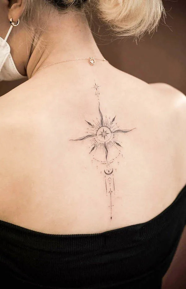 Beautiful spine tattoo featuring the sun and moon, created by @sukza__art