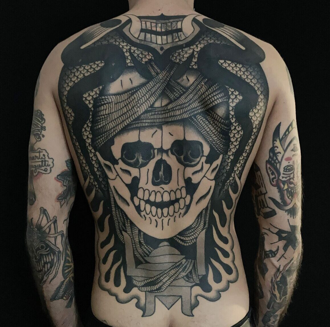 An intricate black line tattoo on a person's arm