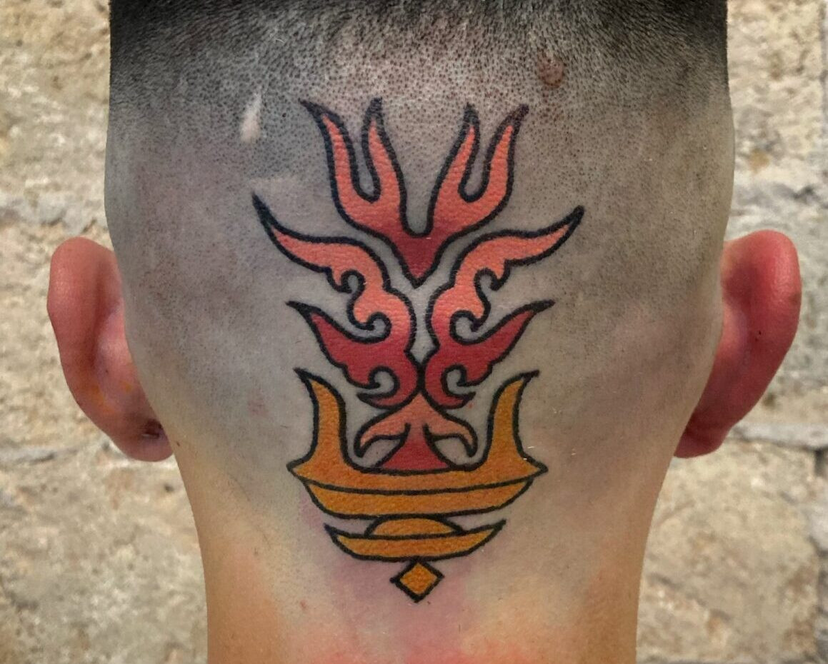Detailed black tattoo art on a person's upper back