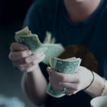 Tattoo artist smiling while holding cash tips