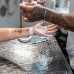 Tattoo artist applying second skin film to client, ensuring a clean and protected healing process