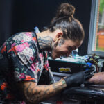 tattoo artist tattooing an arm