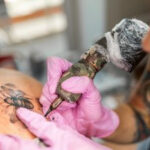 A tattooist working on a detailed design.