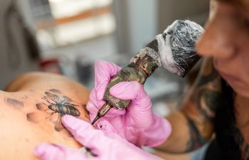 A tattooist working on a detailed design.