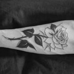 Rose tattoo with a banner design featuring personalized lettering
