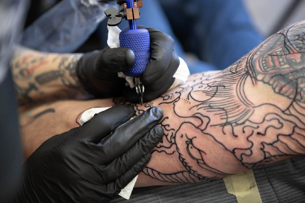 Artist tattooing a detailed back piece