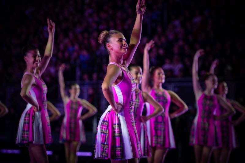 Highland dancers in vibrant costumes performing at The Royal Edinburgh Military Tattoo, showcasing traditional Scottish dance