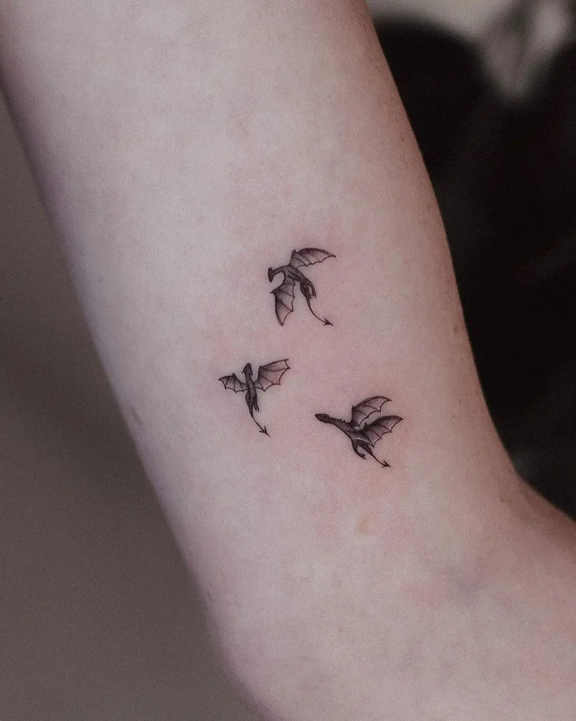 A tiny dragon tattoo with watercolor style, symbolizing a small yet potent symbol of power.