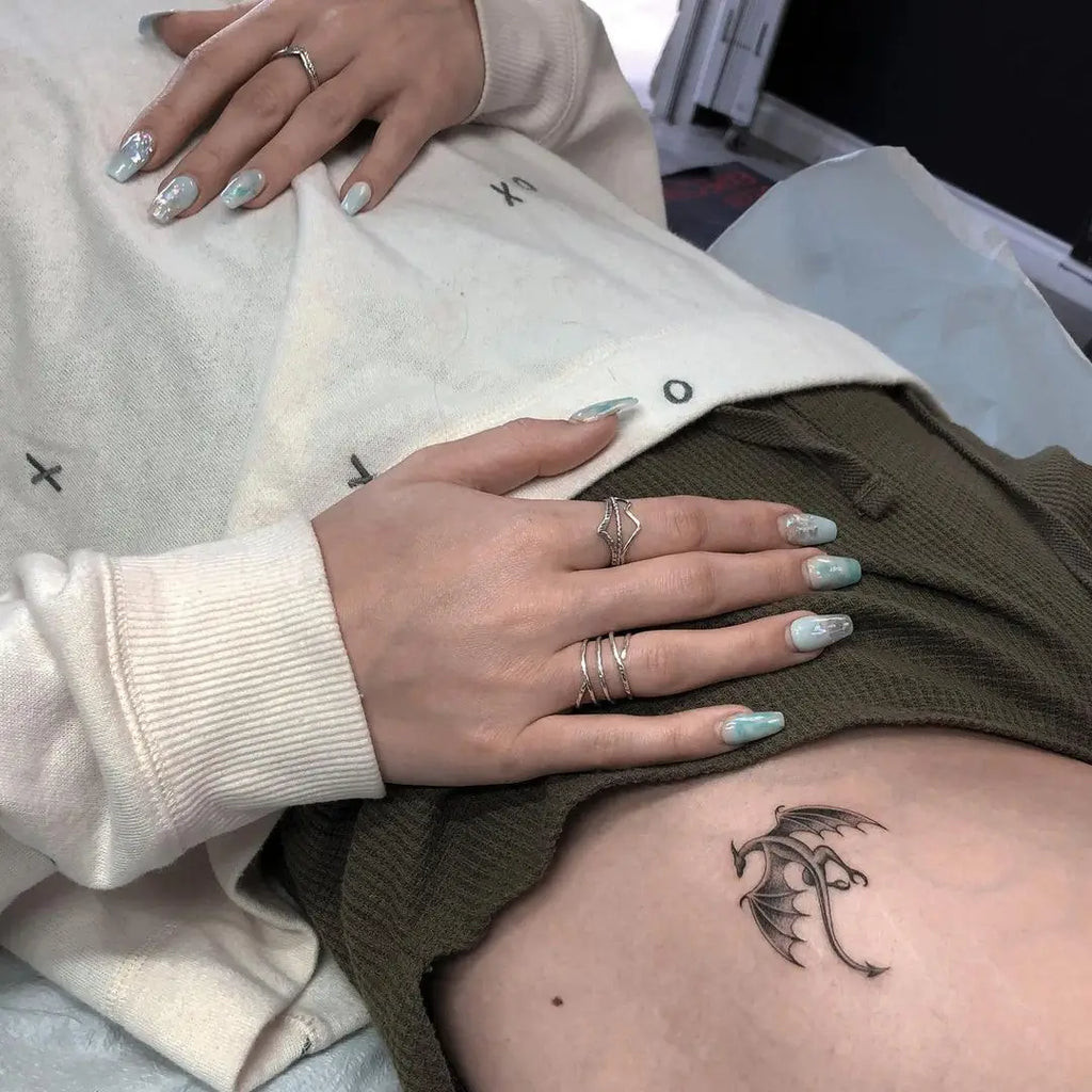 A tiny dragon tattoo on a person's nape, symbolizing a small yet potent symbol of power.