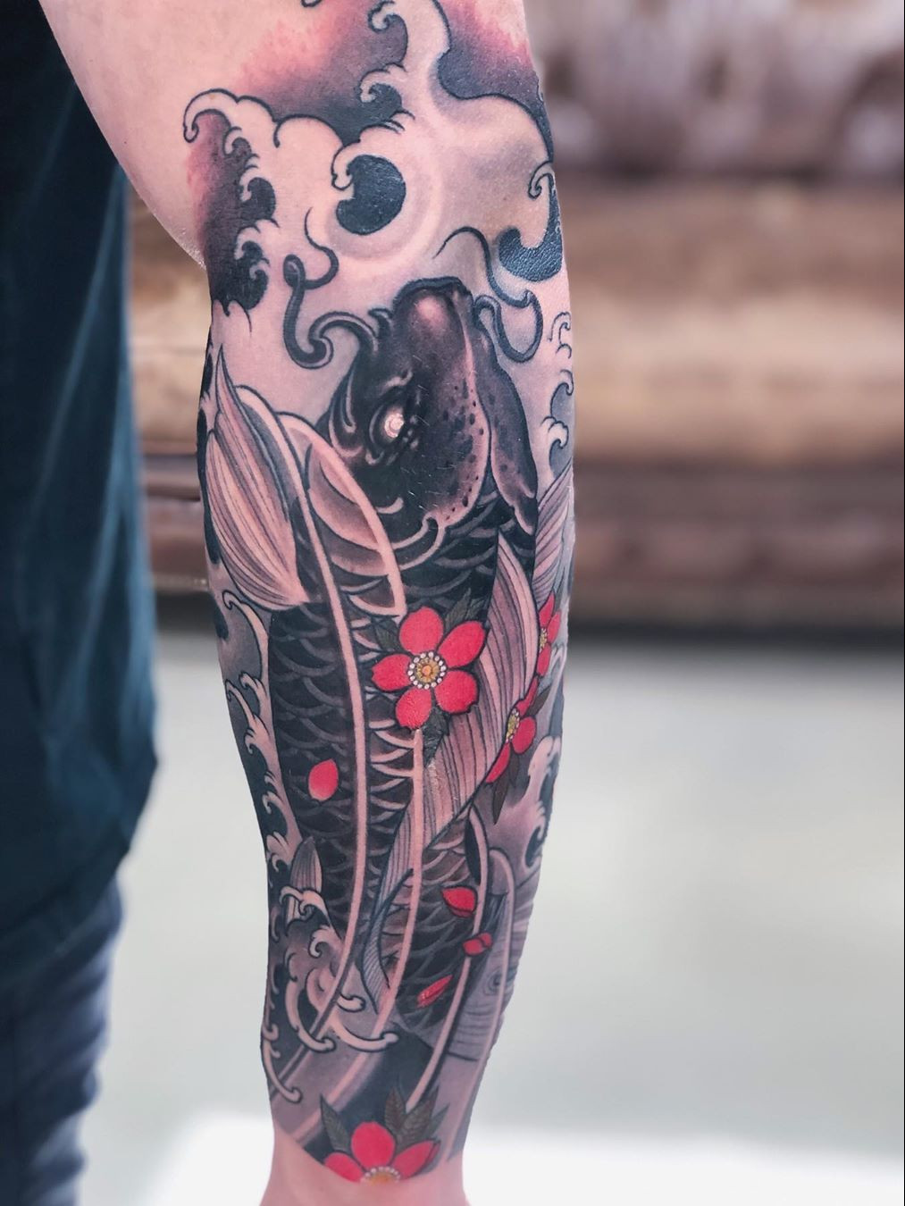 An artistic tattoo design showcasing a Japanese cherry blossom branch combined with traditional Japanese wave patterns.
