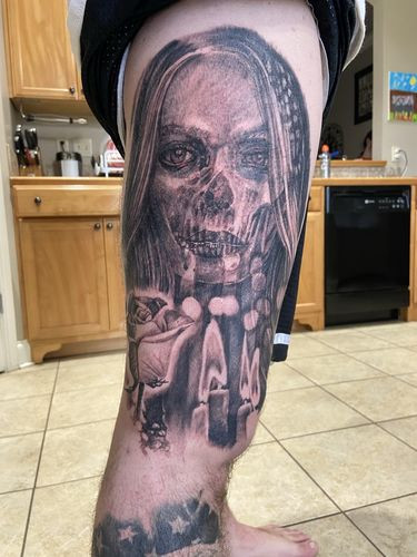 Grim reaper skull tattoo on the outer thigh with a vertical design