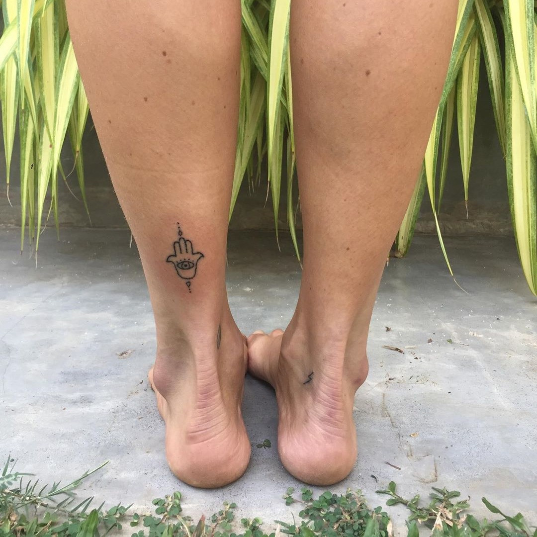 A downward-facing Hamsa tattoo with intricate detailing, symbolizing blessings and answered prayers