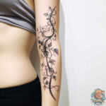 An elegant vine tattoo winding around an arm