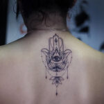 An intricate Hamsa tattoo design featuring geometric patterns and an eye in the center, symbolizing protection and spirituality