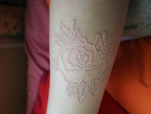 Collection of white ink tattoos on various body parts, showcasing the diversity and artistry of the designs